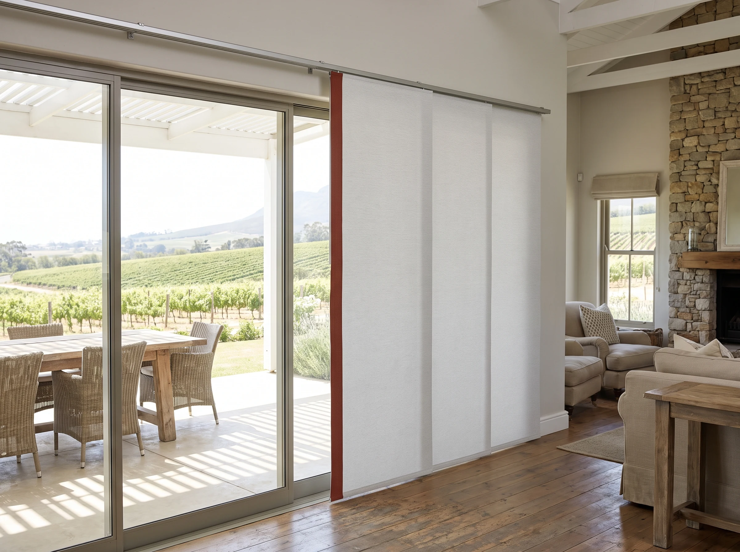 Vertical panel-glide blinds on wide sliding glass doors opening onto a patio near Klapmuts, vineyard visible beyond